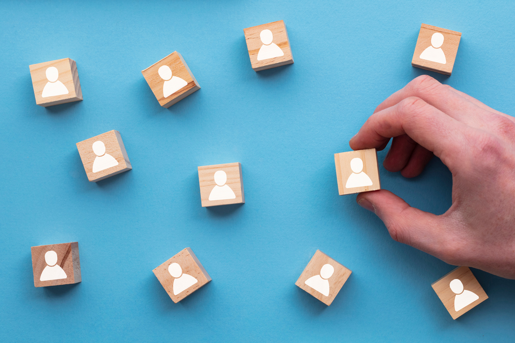 Hand Choosing a Wooden Person Block 